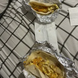 two burritos wrapped in aluminum foil