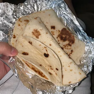 a person holding a tortilla wrapped in foil