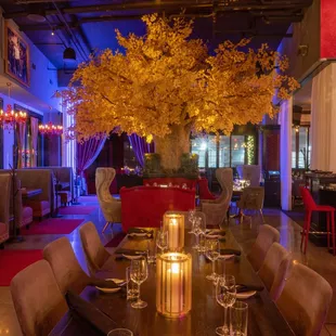 a dining room with a tree in the center