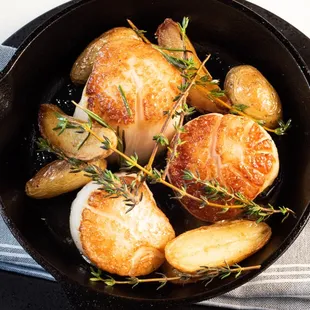 a skillet with chicken and potatoes