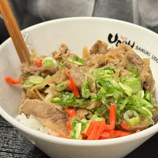 a bowl of food with chopsticks