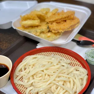 a plate of noodles and a bowl of dipping sauce
