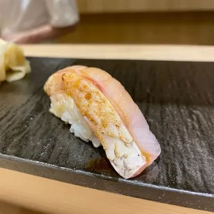 a piece of sushi on a black plate