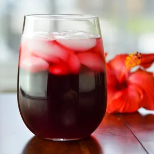 a glass of red wine with ice
