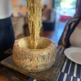 noodles being poured into a wooden bowl