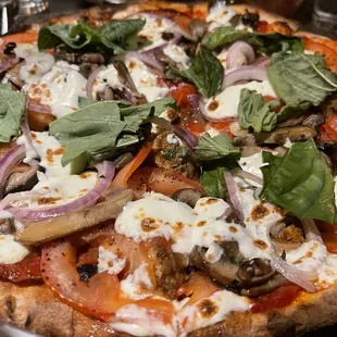 A custom pizza that was filled with fresh vegetables and tasty meats