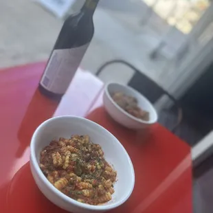 a bowl of pasta and a bottle of wine