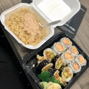 a tray of sushi and a container of rice
