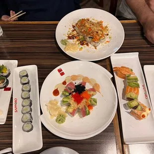 (From Left to Right) veggie roll, cucumber roll, (top) volcano roll, (bottom) Christmas roll, orange dragon roll, avocado roll