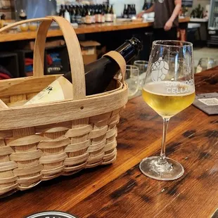a basket of wine and a glass of wine