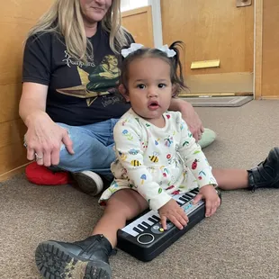 Toddler student playing piano  in a Toddler music class.