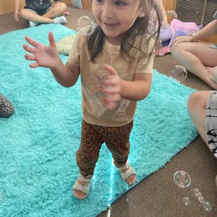 Toddler playing with bubbles in a toddler music class.