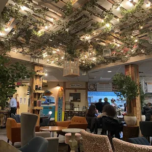 a restaurant with plants on the ceiling