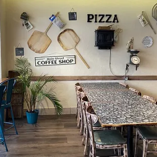 a table and chairs in a pizza shop