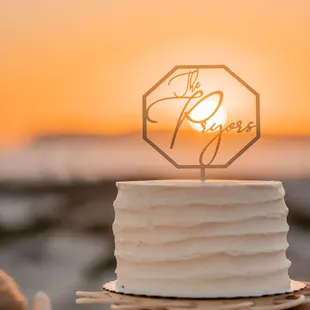 a wedding cake with the sun setting in the background