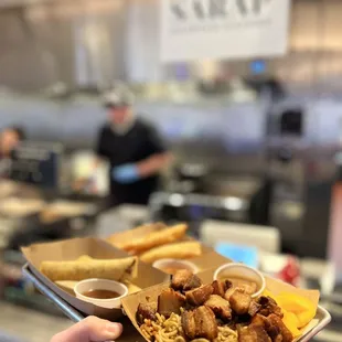 Foreground - Pancit with Lechon Kawali (deep fried pork belly). Back - beef lumpia and (limited time) apple pie lumpia