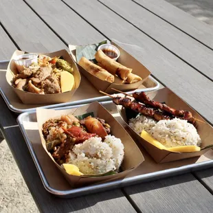 three trays of food on a picnic table