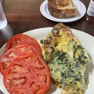 Western omelette with sliced tomatoes and spinach added