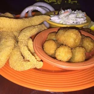 a plate of fried fish and a bowl of coleslaw