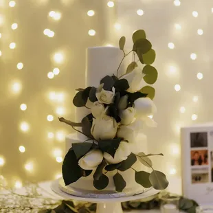 a wedding cake with white flowers and greenery