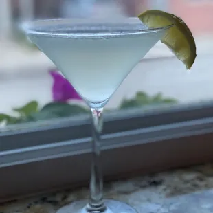 a martini glass with a lime slice on the rim