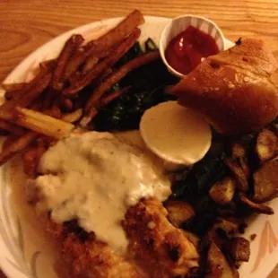Chicken fried chicken, spinach, fries, skillet potatoes, and bread.