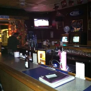 a bar with a television and wine glasses