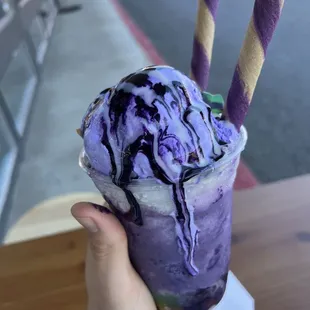 a hand holding a purple ice cream