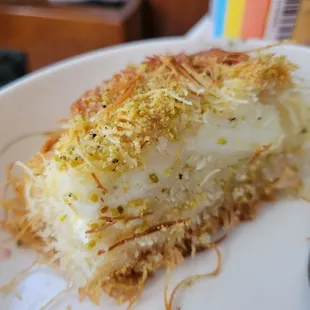 I have no clue what this is called.  The receipt says Faysalya (faysalieh). Shredded dough, custard, pistachio. Yum.