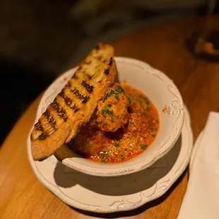 a bowl of soup with grilled bread