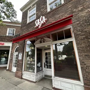 a brick building with a red awning