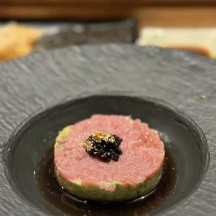 a dish of sushi on a black plate