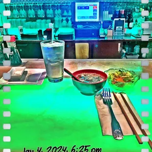 a bowl of soup and chopsticks on a table