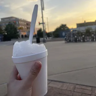 a hand holding a cup of shaved ice