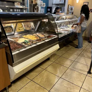 a woman standing in front of a deli counter