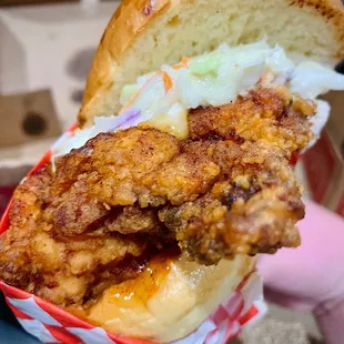 a hand holding a fried chicken sandwich