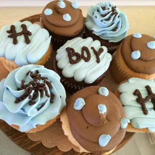 a plate of cupcakes with blue frosting