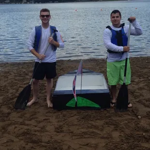 two men on the beach with paddles