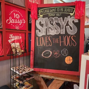 a chalkboard sign for sassy's loves the hogs