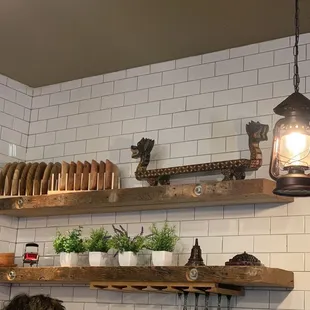 a kitchen with white tiles and wooden shelves