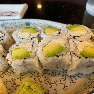 a plate of sushi with avocado