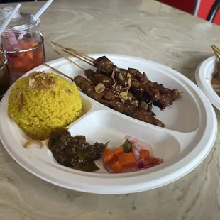 Pork skewers, chicken skewer, yellow rice, and free pickle/and spicy paste (not sure of the name).