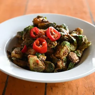 a white bowl filled with vegetables on a wooden table