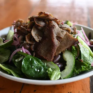 a plate of salad with meat and vegetables
