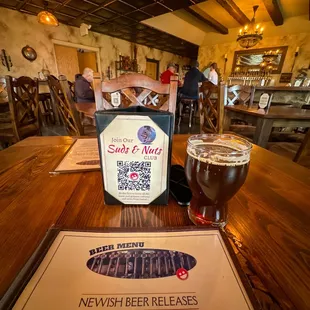 a glass of beer and a menu