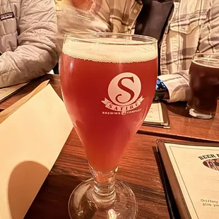 a man sitting at a table with a glass of beer