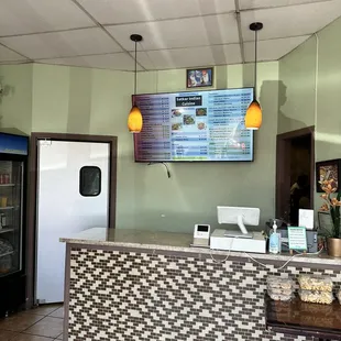 a counter with a menu on the wall