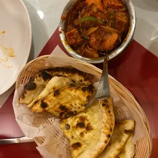 a plate of naan bread and a bowl of curry