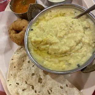 114. Pongal Vadai creamy lentil stew with a delicious fried lentil, doughnut, and assorted curries.