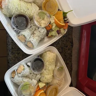two containers of sushi on a table